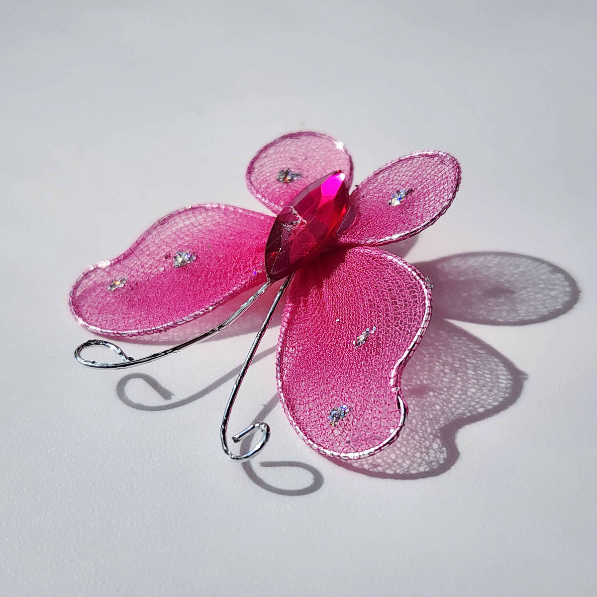 pink butterfly made of mesh fabric and wireon a white background
