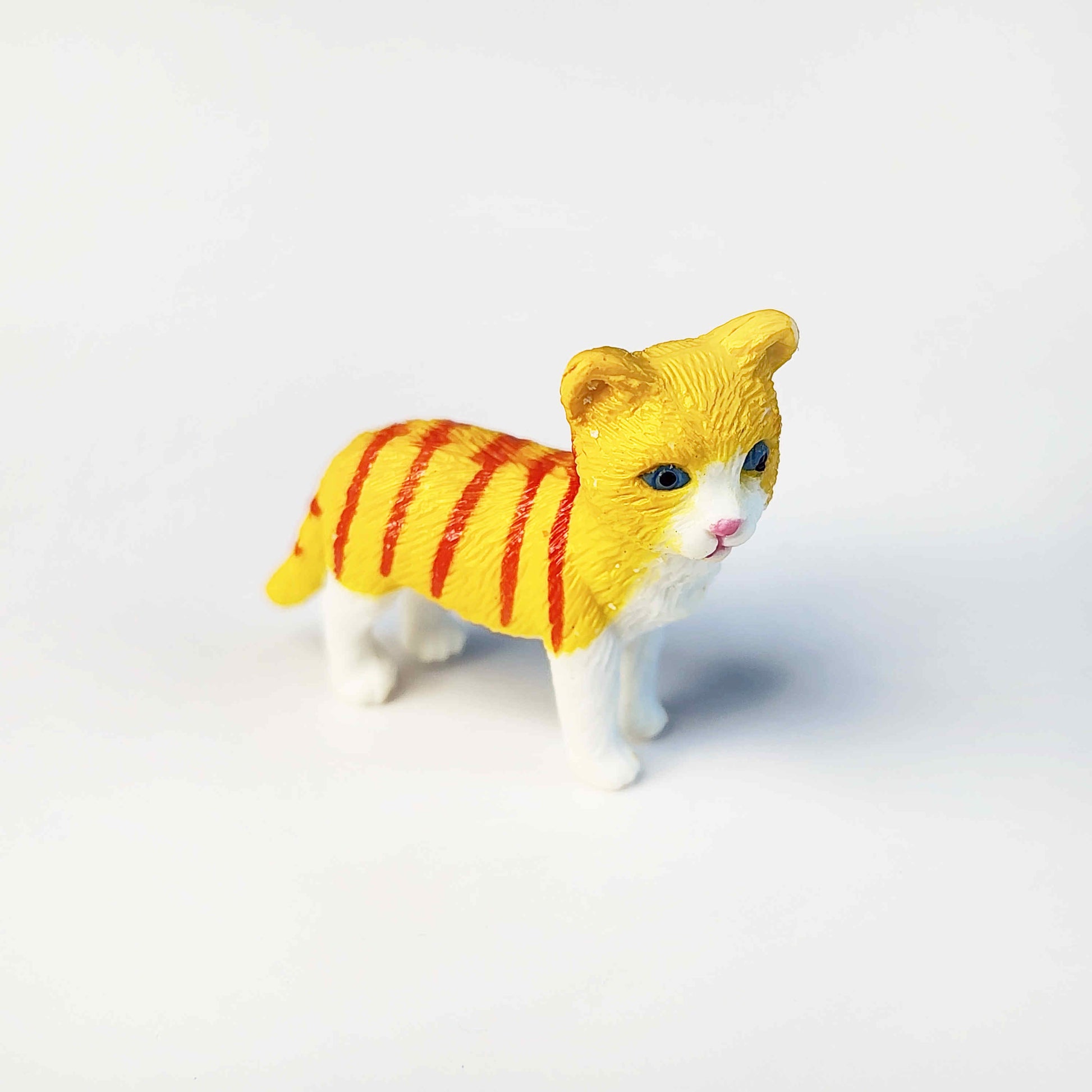 orange striped tabby pvc cat figurine on a white background